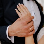 husband hand holding wife hand at wedding